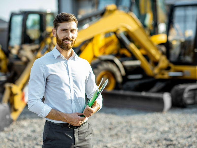 Ingeniero frente a maquinaria pesada en un sitio de construcción, decidiendo dónde comprar maquinaria pesada en México.