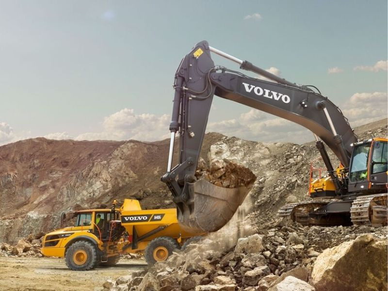 Excavadora y camión Volvo trabajando en un proyecto de movimiento de tierras.