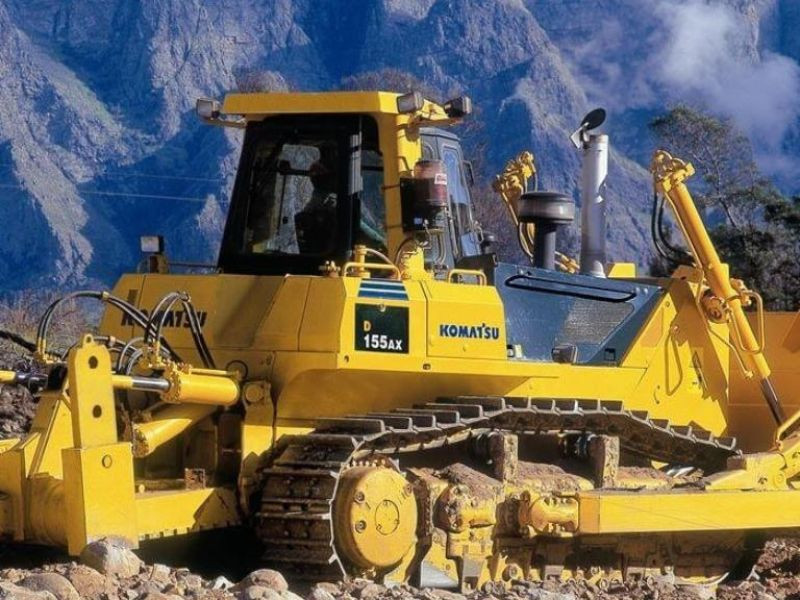 Bulldozer Komatsu D155AX trabajando en terreno montañoso.