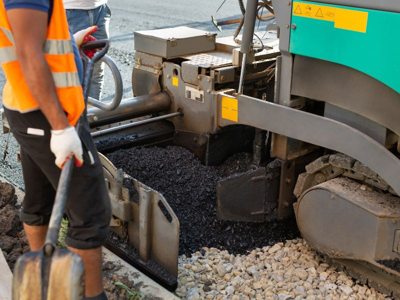 Pavimentadora colocando asfalto en la construcción de una carretera.