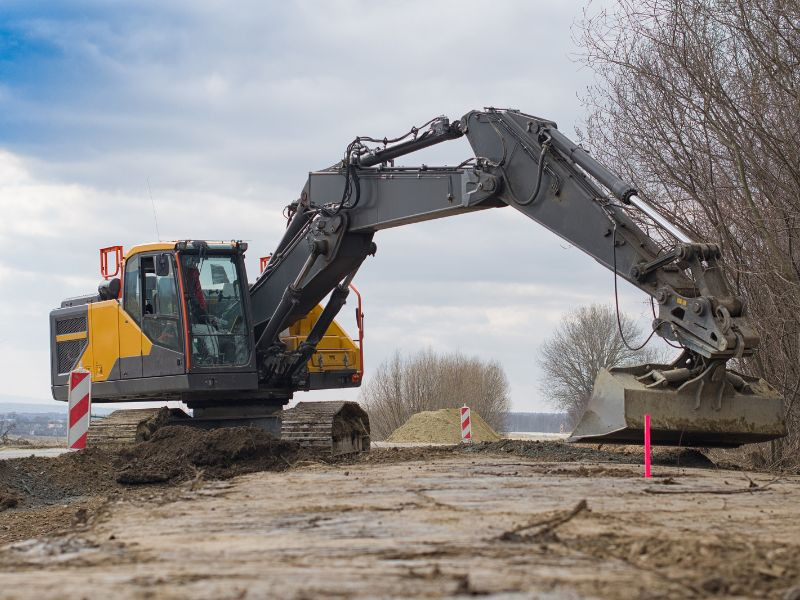 Excavadora trabajando en la pavimentación de una carretera.