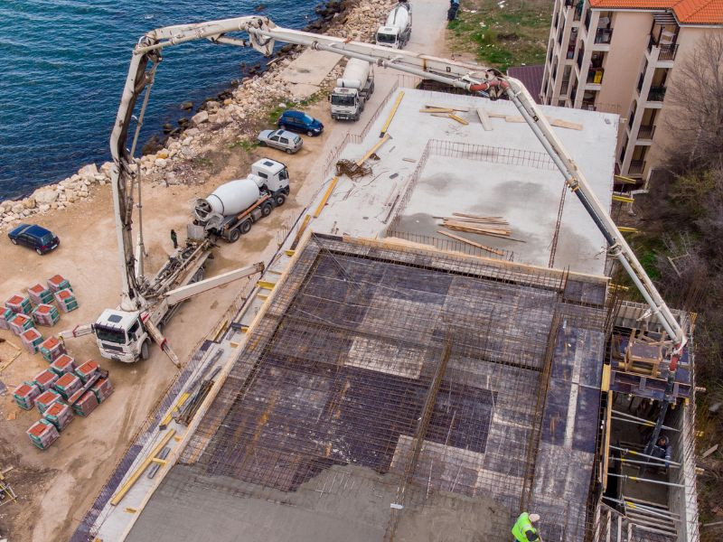 Bomba de concreto bombeando hormigón en una construcción cerca del mar.