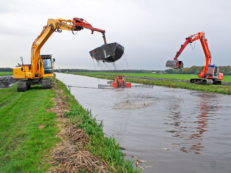 Excavadora dragalina limpiando un canal de agua