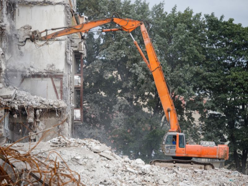 Excavadora ralizando trabajos de demolición en la remodelación de una obra civil